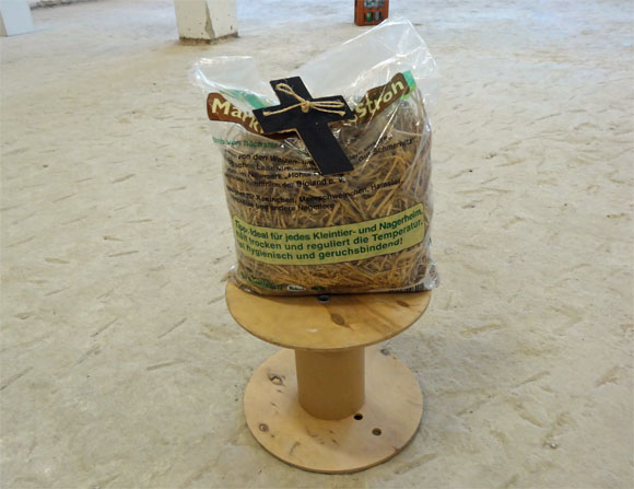 Heinz Helmut Zwanzig:  Heiliger Strohsack, 2005, Stroh, Plastik, Karton, Schnur auf Kabelsockel, 50 x 40 x 20 cm